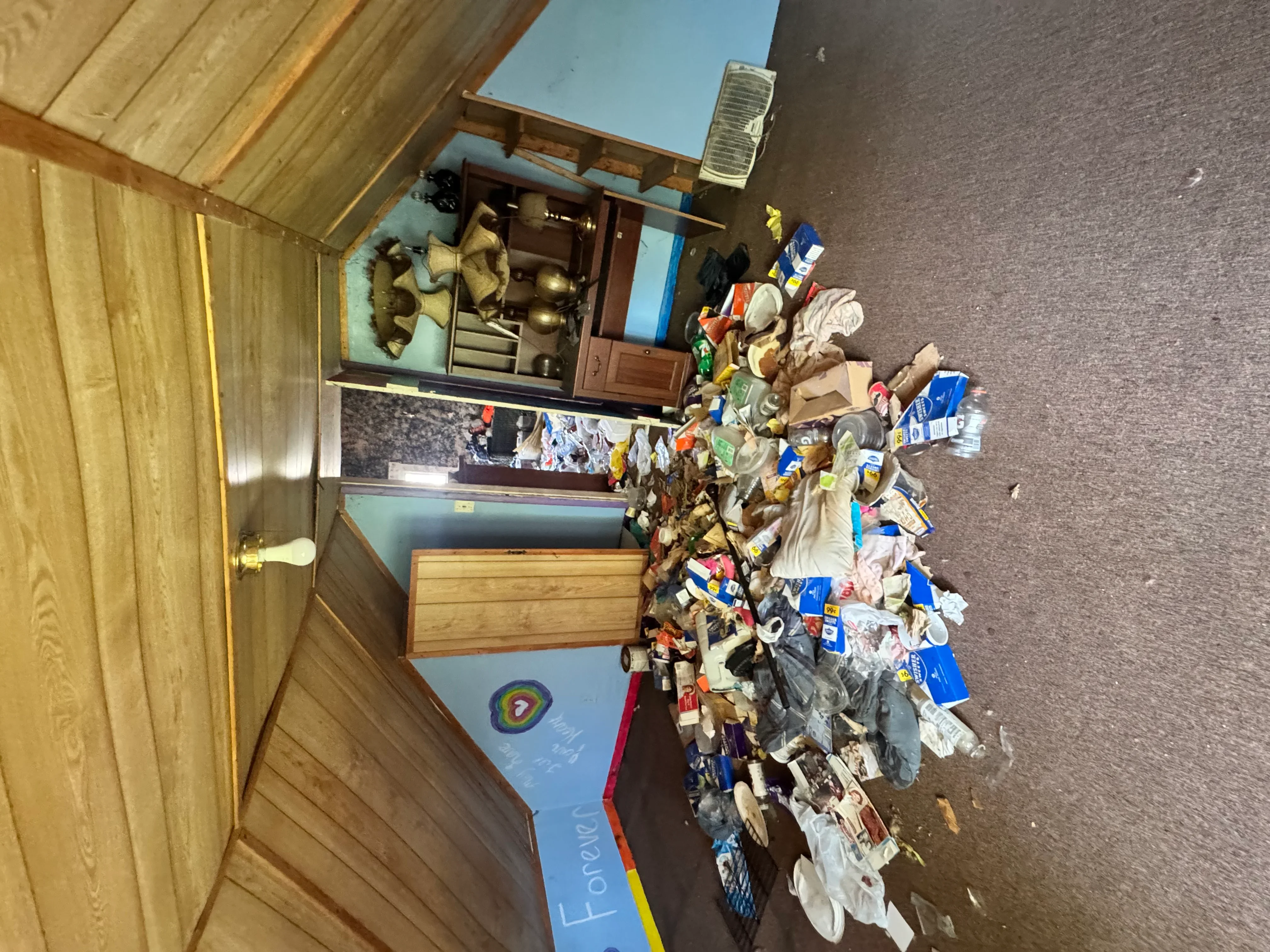 Interior room with accumulated junk and household items cleared during residential cleanup project