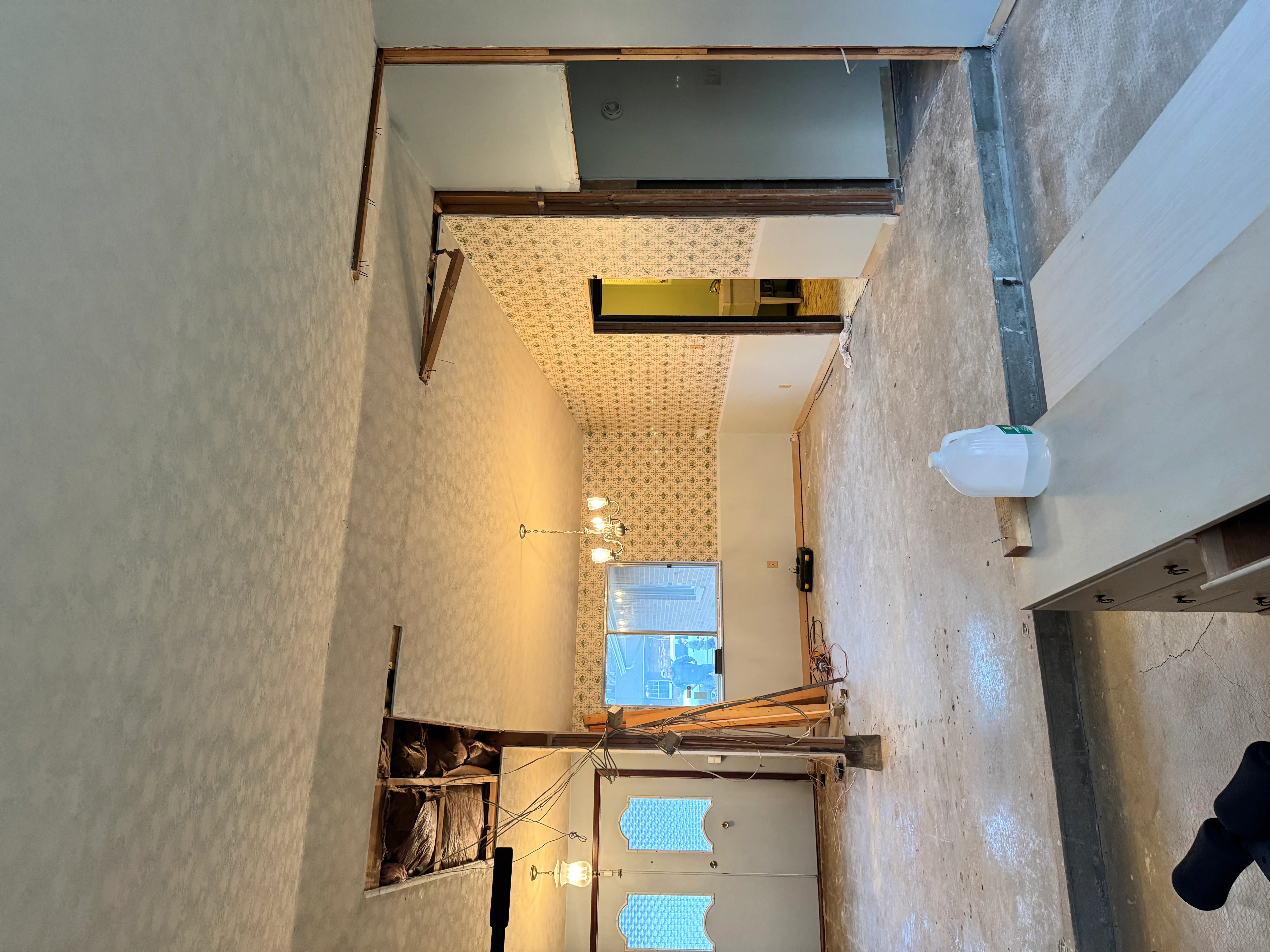 Renovated bathroom with geometric tile flooring, white walls, brass mirror frame, and recessed lighting