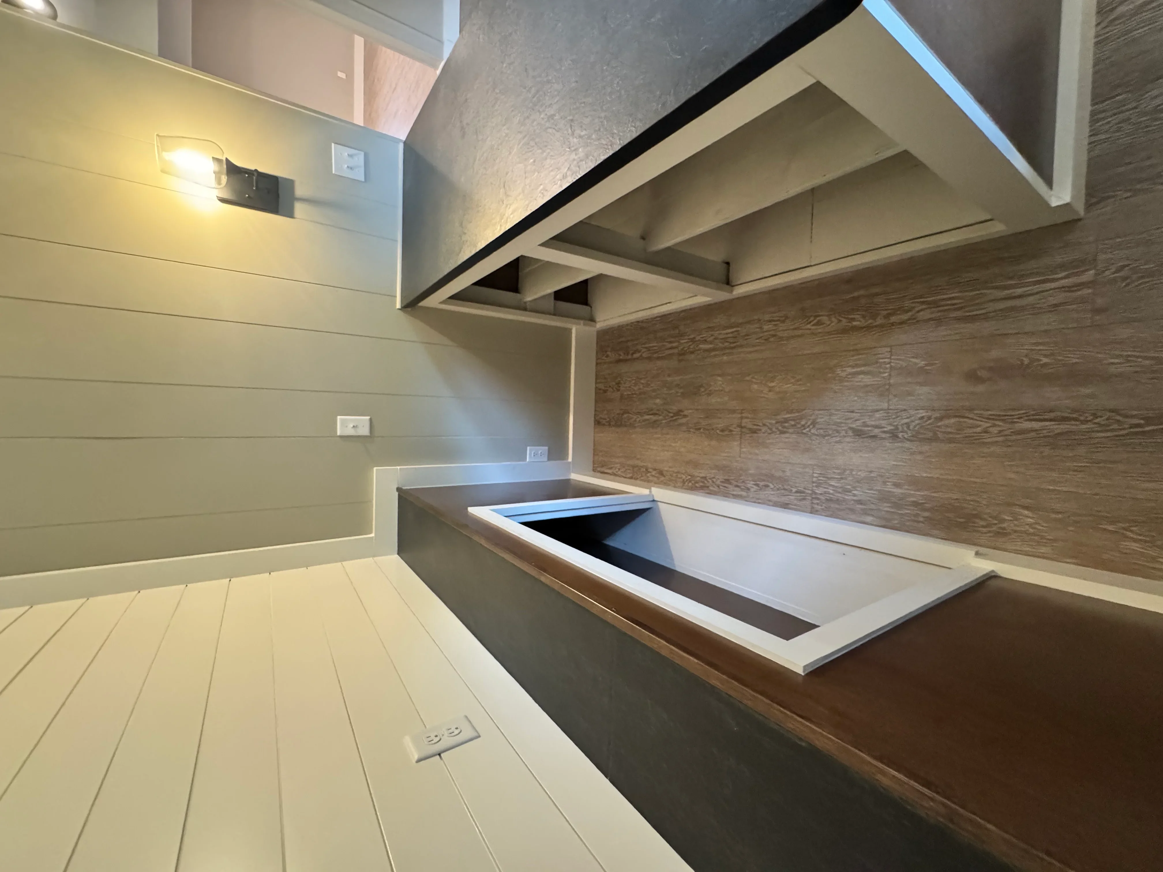 Modern kitchen with white cabinetry, wood accents, and waterfall island countertop