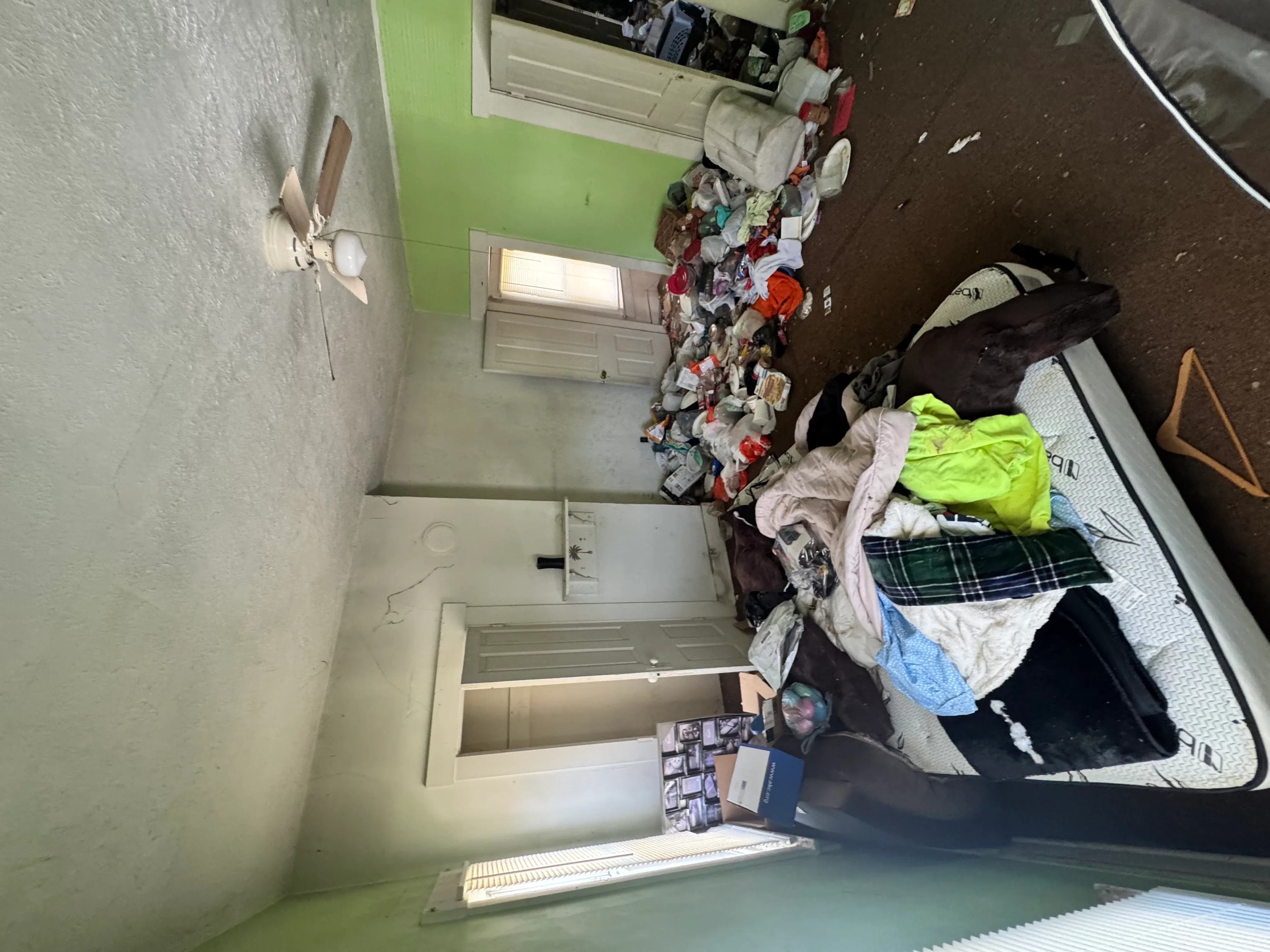 Empty bedroom with lime green accent wall after junk removal and cleanout service
